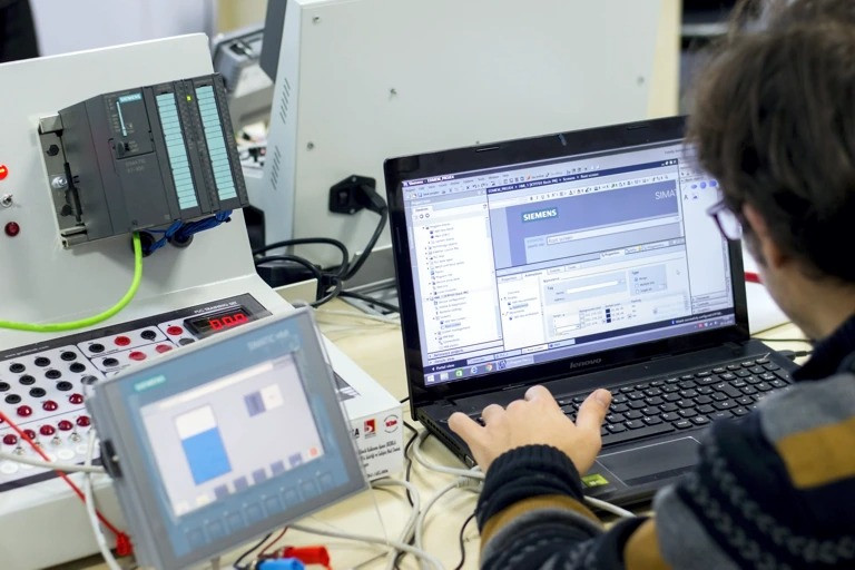 Inteligentne liczniki energii podłączone do systemu monitorowania mediów w hali przemysłowej.